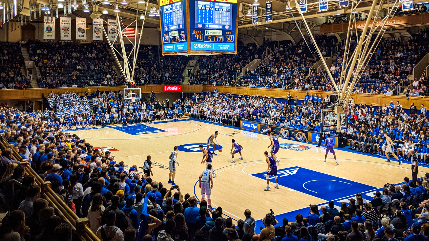 Photograph from Duke men's basketball game, showing action on the floor and a sold out crowd at Cameron Indoor Stadium.