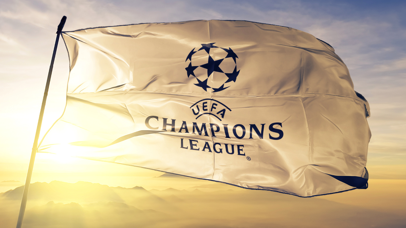 Image of Champions League flag waving in the air with the sun setting in the background.