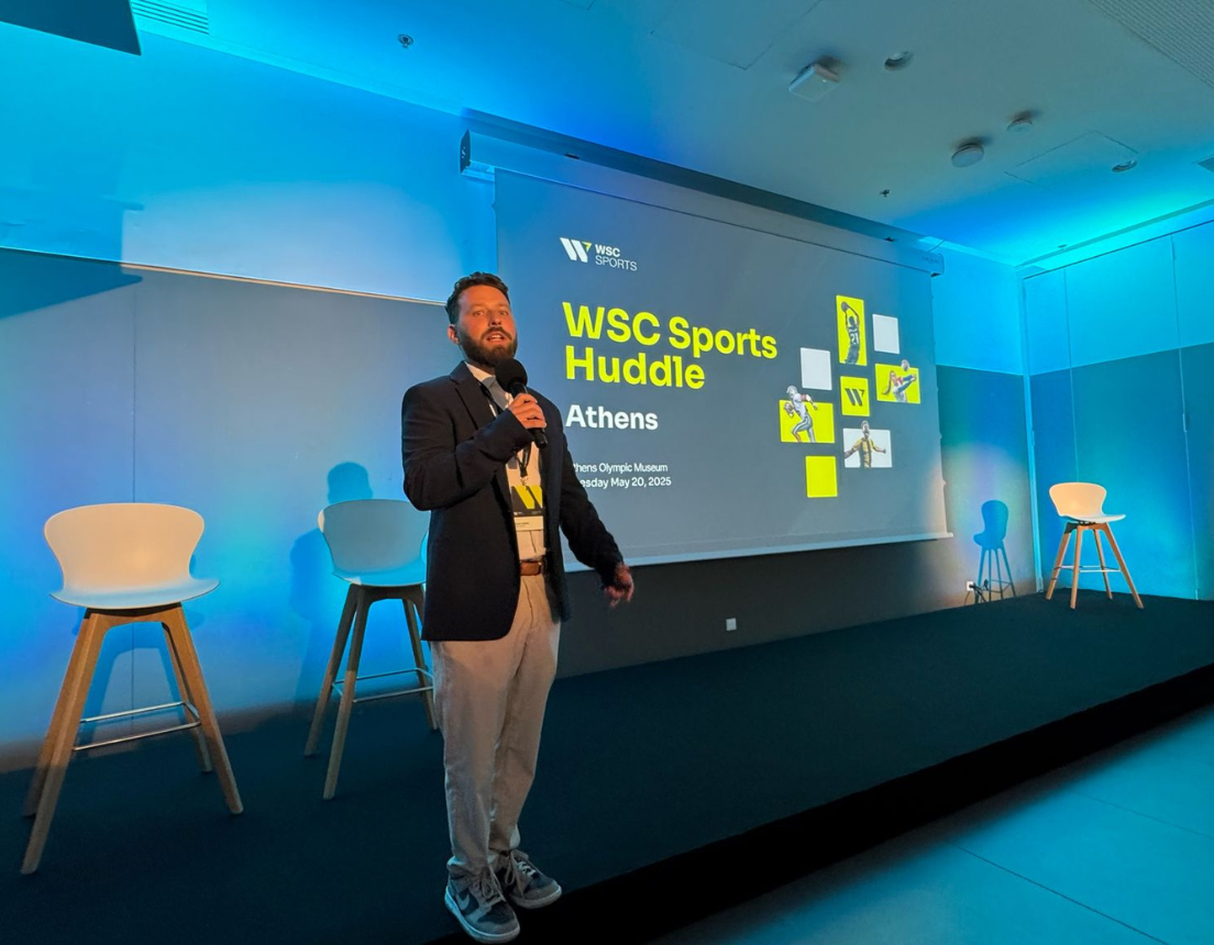 WSC Sports' Adam Haliva stands on stage kicking-off 2025 Athens Huddle.