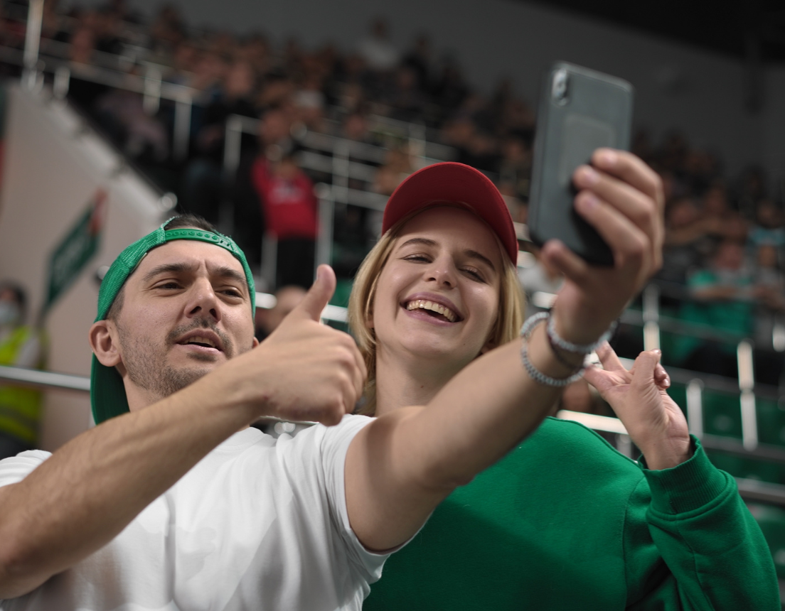 Two fans at a hockey game take a selfie.