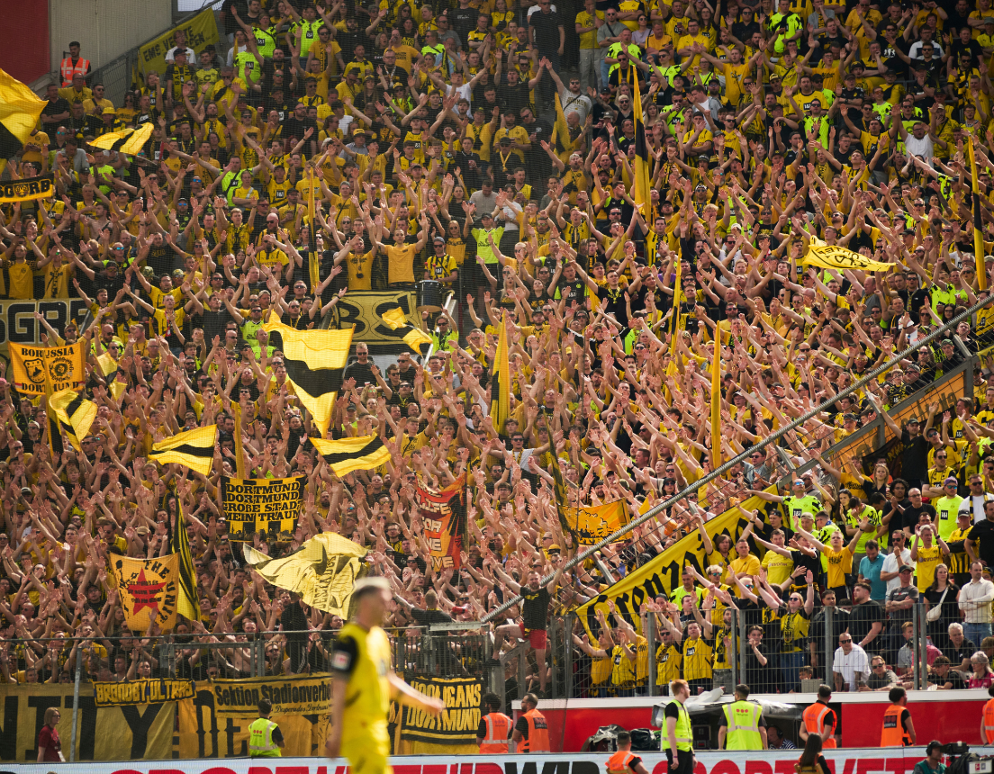 Dortmund fans stand and cheer on their side with passion